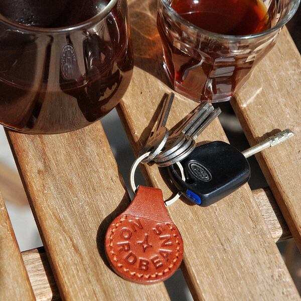 Kožený přívěsek s nápisem Nordbeans na klíče.